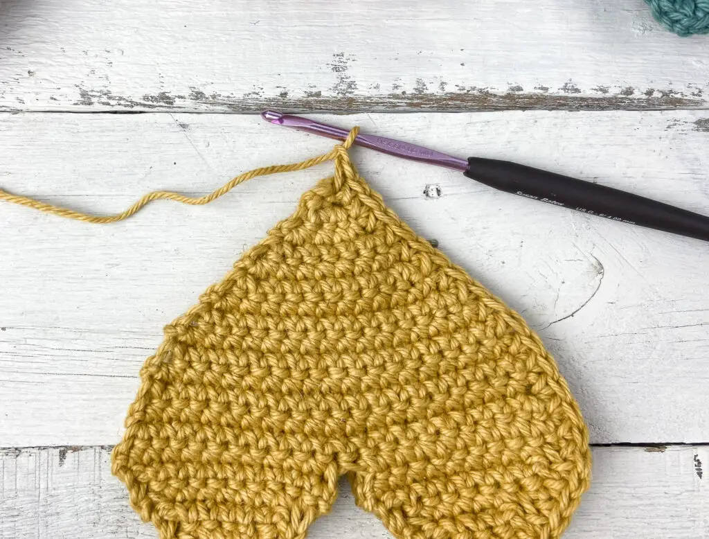 (sc, ch 1, sc) at the tip of the crochet heart to create a point