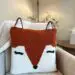 a crochet orange and white fox pillow sites on a white chair.